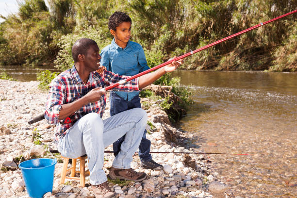 istock Man and boy fishing with rods 1299901991