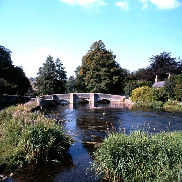 Red brick arched bridge with metal railing over the Avon river (Bristol Avon) at Upper Woodford near Salisbury in Southern England, United Kingdom
