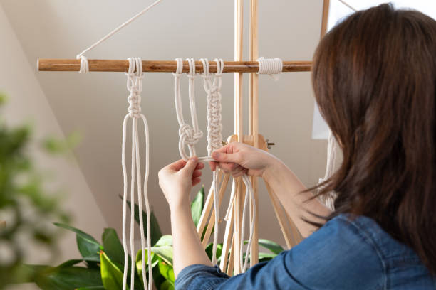 Woman relaxing and making macrame at home with different knots. Stay at home hobbies. Woman relaxing and making macrame at home with different knots. Stay at home hobbies. macrame stock pictures, royalty-free photos & images