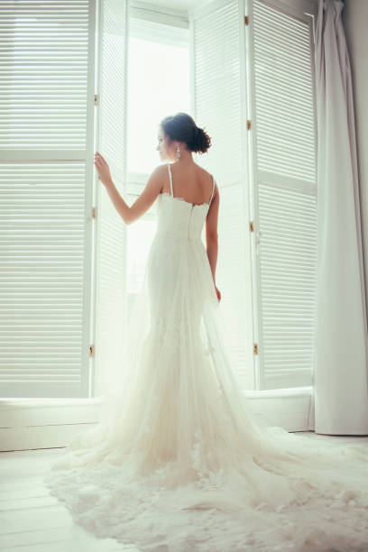 istock bride in dress near window 1299905867