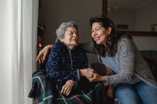 stara chora kobieta na wózku inwalidzkim obok uśmiechniętej córki. - aging process women human face daughter zdjęcia i obrazy z banku zdjęć