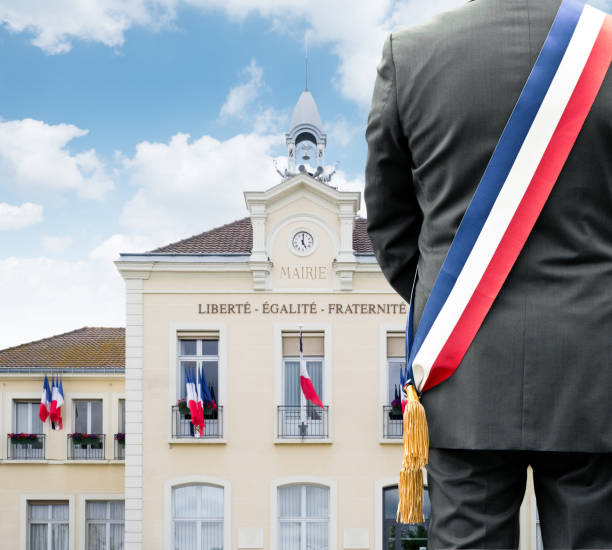 A mayor in front of his town hall A mayor with his tricolor scarf in front of his town hall town hall government building photos stock pictures, royalty-free photos & images