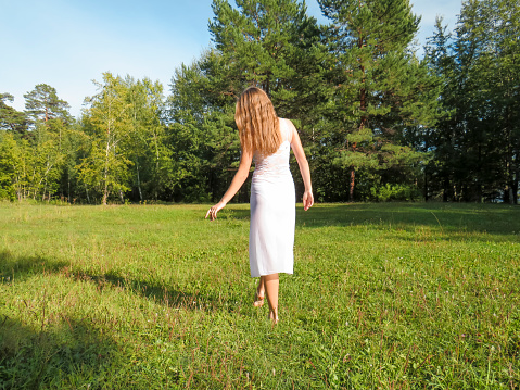 Young Woman in White Silk Dress Walking in Nature