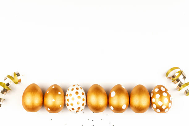 istock Easter festive decoration.Top view of easter eggs colored with golden paint on white background. Various dotted designs 1299906865