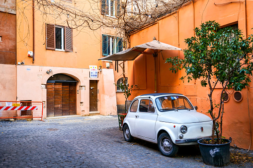 Rome, Italy, September 29 -- A vintage Fiat 500, symbol of Italian design and industry present in the MoMA museum in New York, parked in a street in the center of Rome in the old Trastevere district. Image in High Definition format.