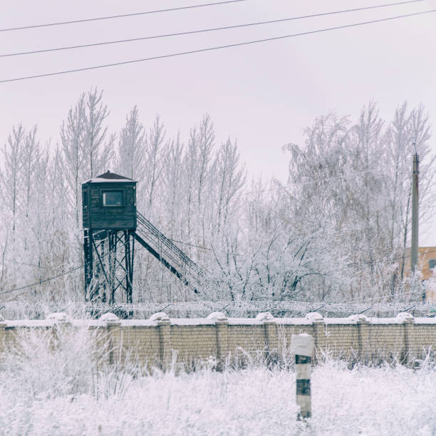 torre de la prisión en la cerca con alambre de púas. en invierno en la nieve - winter wire barbed wire protection fotografías e imágenes de stock