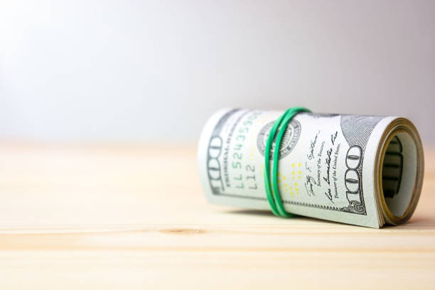 istock Money roll on wooden table 1299915462