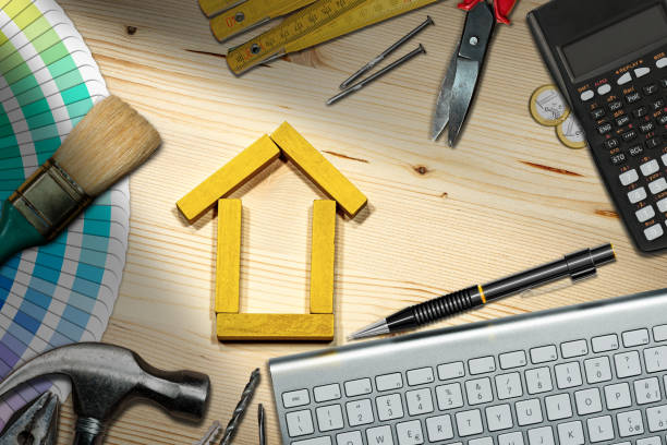 istock Small Wooden House with Work Tools on the Desk - Home Improvement 1299915511