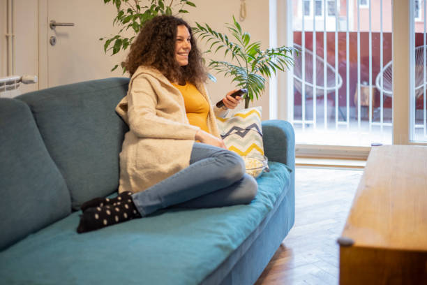 istock Pregnant woman watching television 1299916006