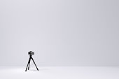 Photo and video tripod with nonexistent DSLR camera on the white backgound