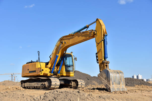 istock Excavator on earthworks at construction site. Backhoe on foundation work and road construction. 1299919231