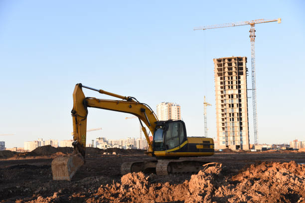 istock Excavator on earthworks at construction site. Backhoe on foundation work and road construction. 1299919427