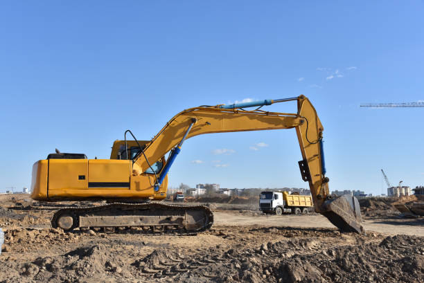 istock Excavator on earthworks at construction site. Backhoe on foundation work and road construction. 1299919759