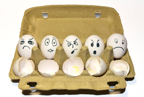 istock Chicken egg in a cardboard with painted emotions on shell among broken empty eggs in a paperboard. 1299919911