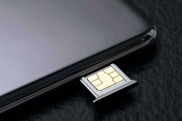 закройте мобильный телефон сим-картой на черном фоне. - sim card стоковые фото и изображения