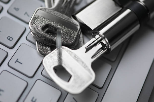istock Silver key with lock lie on white keyboard closeup backround. 1299923942