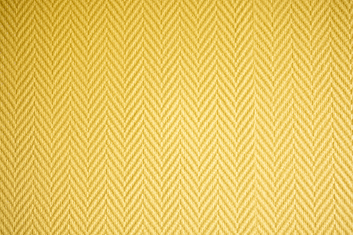 close-up texture of warm fabric for clothing of mustard yellow color in a tartan cell. Image for your design