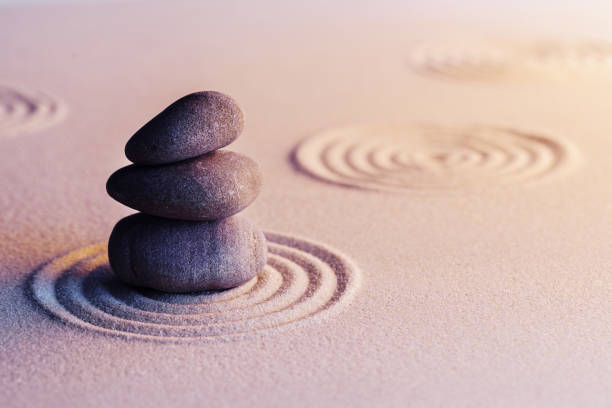 istock Meditation zen garden with stones on sand 1299929399