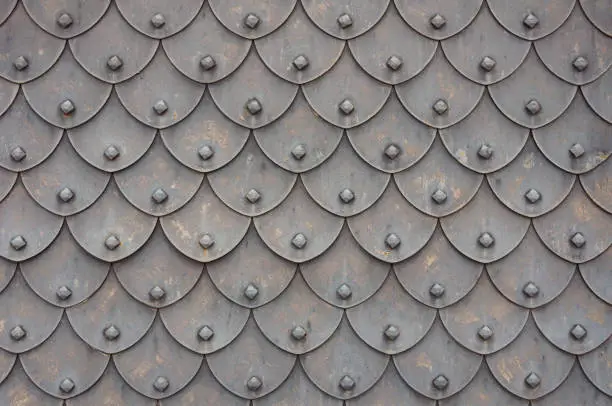 Photo of Medieval rusty metal grey scales armor background. Template for border, frame design.