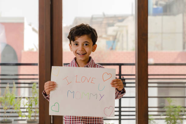 istock Small boy holding mother's day poster in hand 1299931053