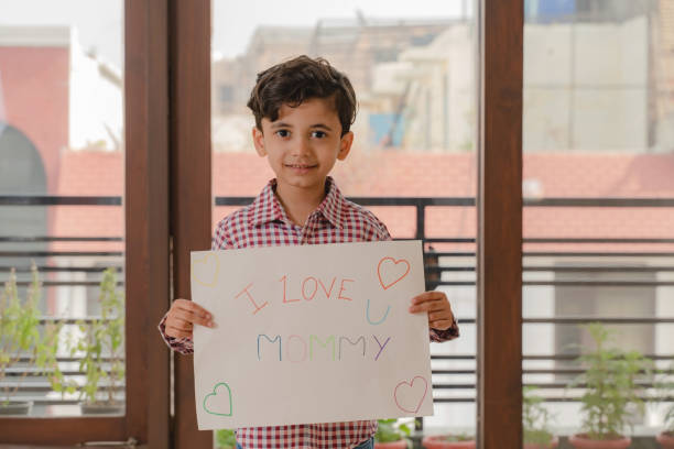 istock Small boy holding mother's day poster in hand 1299931070