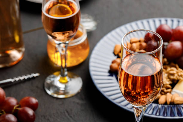 istock Glass of wine and plate with nuts on black table 1299932002