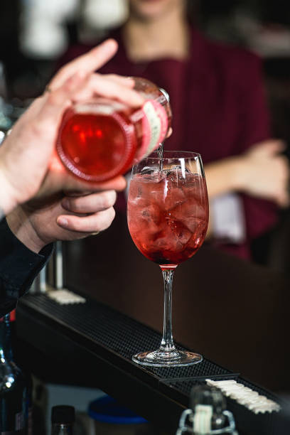 istock bartender making refreshing pink coctail with a rose on top isolated on a bar background 1299932083