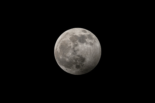 Full moon in the dark winter night with clearly visible moon surface during a partial eclipse in January 2020. Shot with a long telelens.