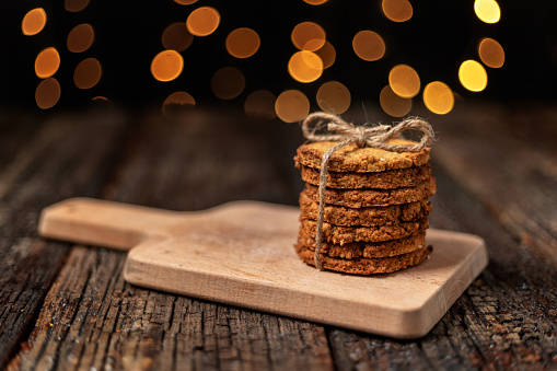 A stack of organic oatmeal cookies for Christmas, with glowing bokeh lights. Close-up. High quality photo