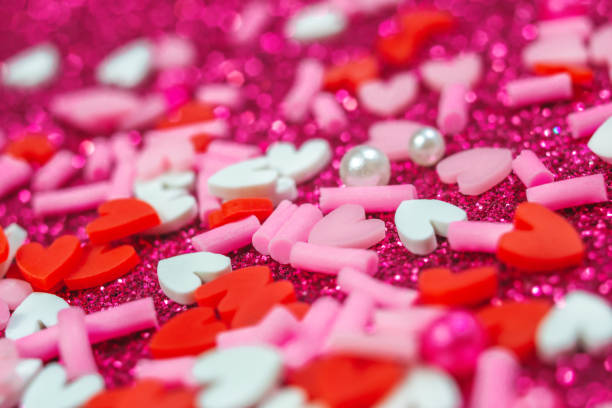 istock Heart candy confetti, pearl on purple sparkle background. Valentines day macro pattern. love wallpaper 1299935919