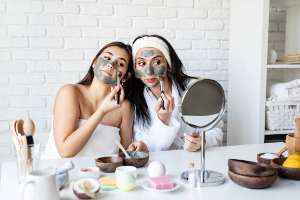 istock two beautiful women applying facial mask having fun 1299937064
