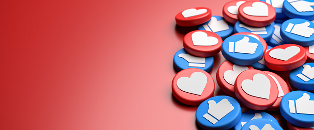 A mix of like buttons with a white heart on red and white thumbs up on blue on a heap. Red background. Social Media Concept. Web banner format with copy space.