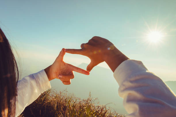 istock woman hand framing looking view sunrise 1299938453