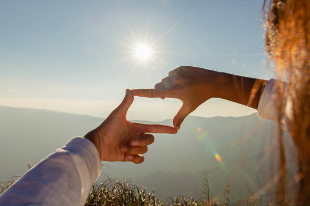 istock close up hand framing looking view sunrise 1299938454