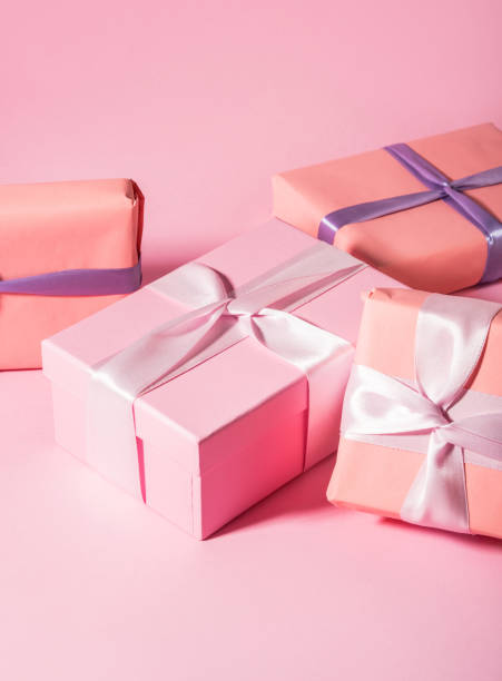 istock Pink wrapped gift boxes with ribbons on monochrome background 1299939902