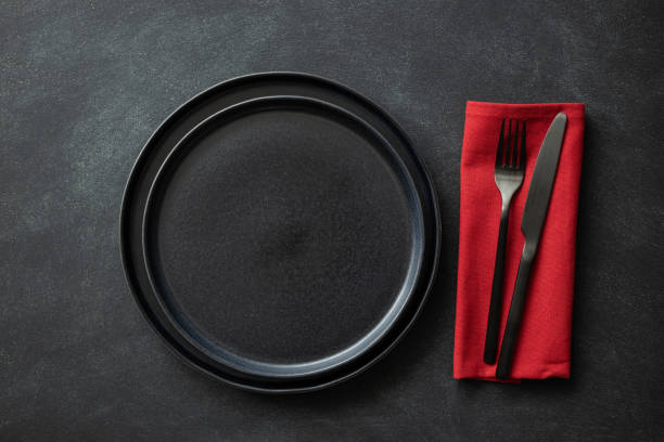 istock Empty black plates with cutlery and napkin. 1299939925