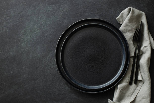 istock Empty black plates with cutlery and napkin. 1299939929