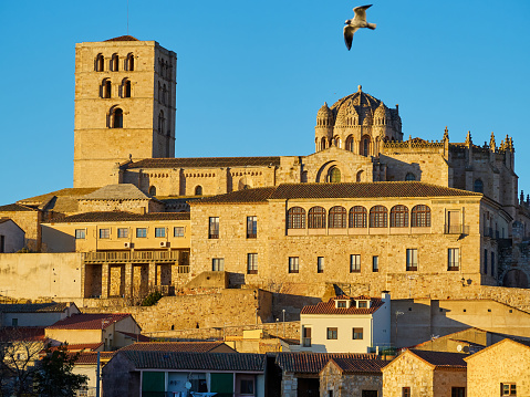 Close up, horizontal view of the cathedral of Zamora at sunset with the Duero river, blue sky free of clouds. Old town of Zamora in Spain.