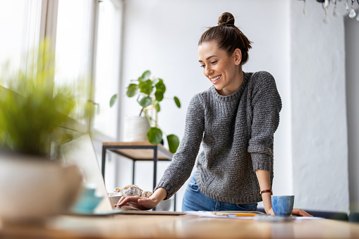 Creative young woman working on laptop in her studio