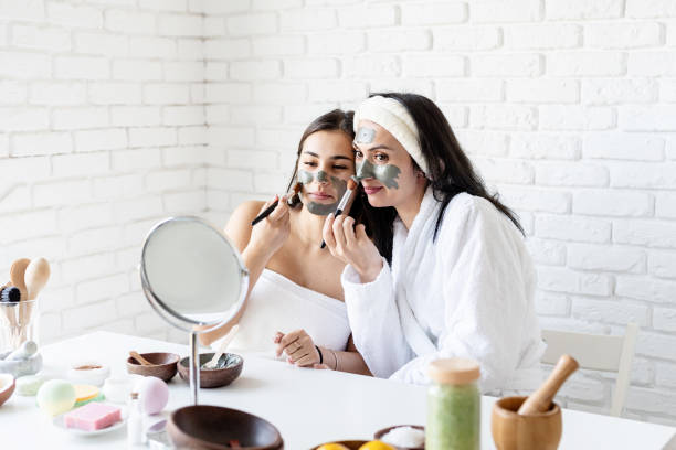istock two beautiful women applying facial mask having fun 1299941841