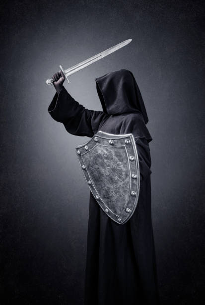 istock Dark knight with sword and shield in the dark 1299942034