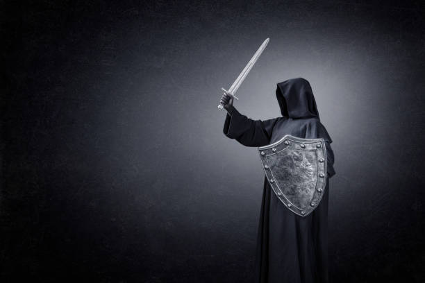 istock Dark knight with sword and shield in the dark 1299942052