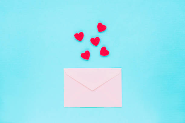 istock Pink envelope and red hearts on a blue background, top view, flat lay 1299942205