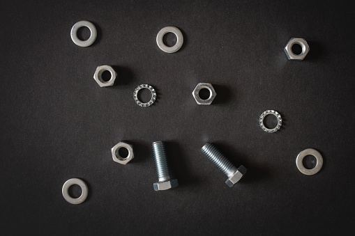 Hardware - bolts, nuts, washers, screws on black gray background