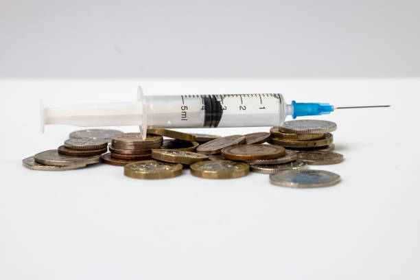 istock syringe placed on top of coins 1299943933