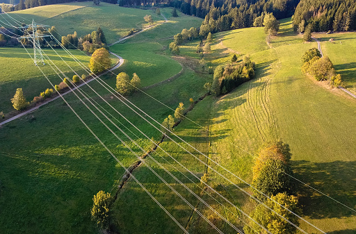 Aerial view, High voltage electricity lines in the field. Agricultural fields and electricity lines. Titisee-Neustadt, Black Forest, Germany