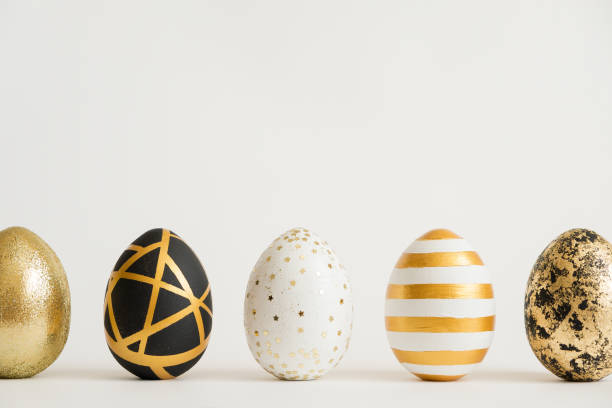 istock Easter golden decorated eggs stand in a row on white background. Minimal easter concept. Happy Easter card with copy space for text. Top view, flatlay 1299944918