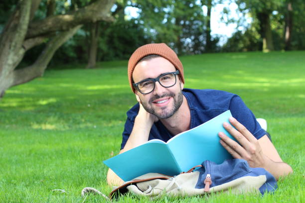 istock Adult student reading in the park 1299945031