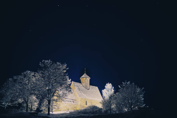 Old medieval church lit up on a cold starry winters night.