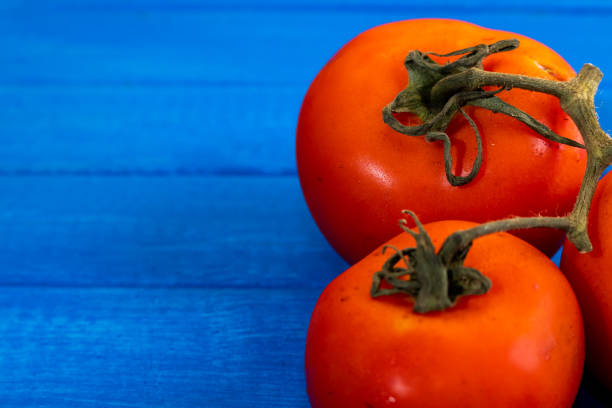 istock Spectacular ripe organic tomatoes on a light blue table. Space to write. 1299946262